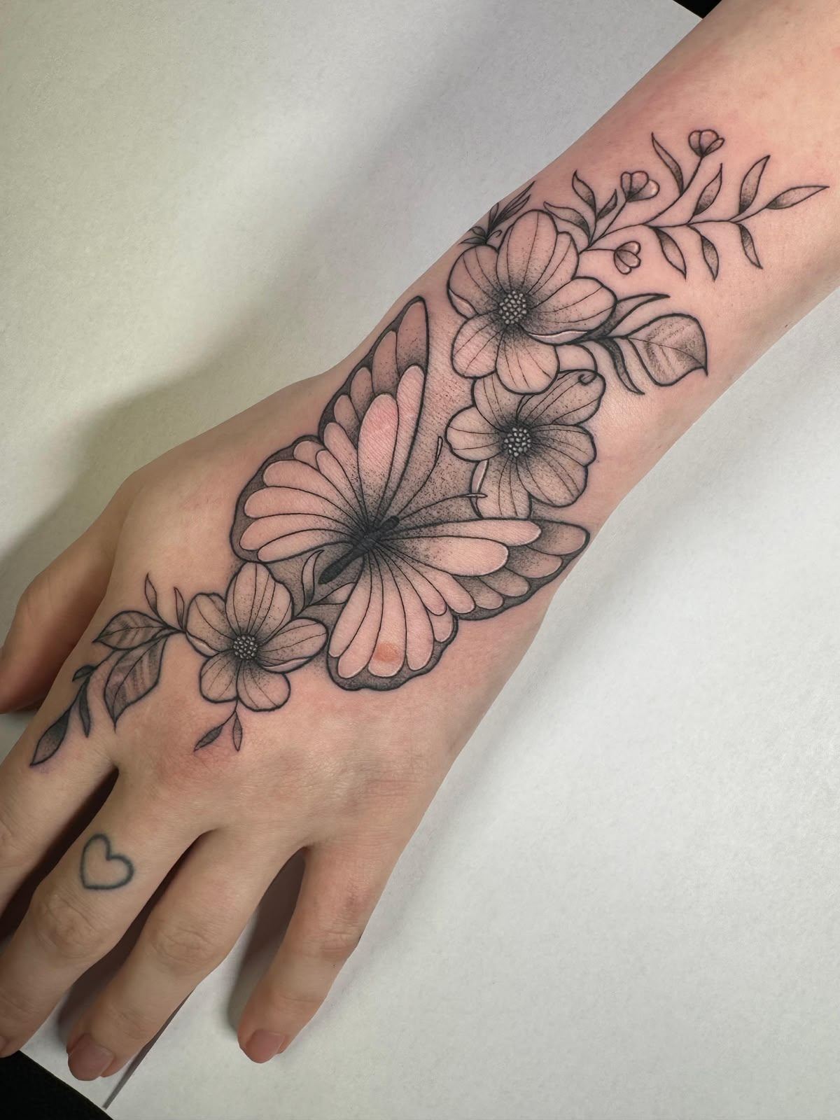 Ornamental butterfly and flowers hand tattoo