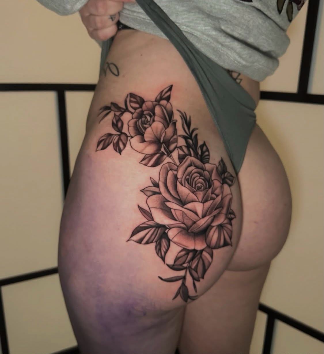 Ornamental black and grey roses tattoo on the hip