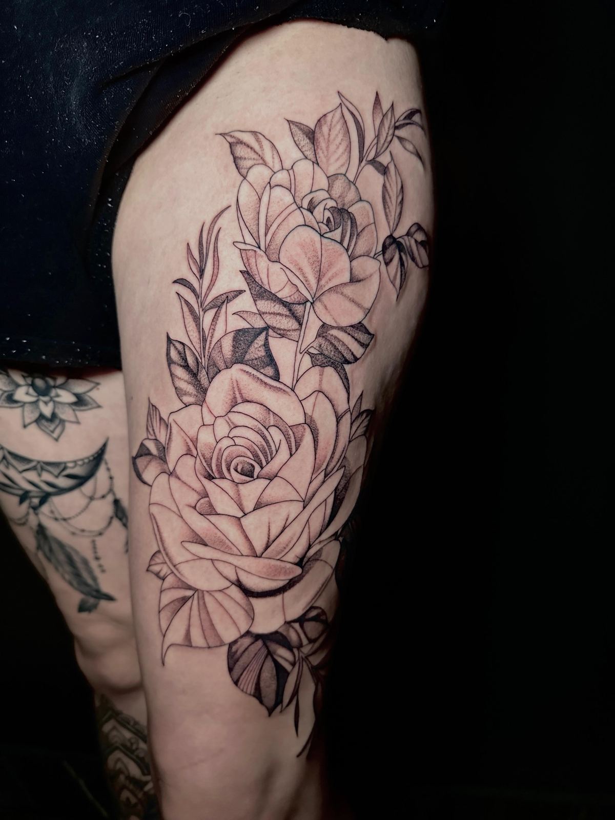 Ornamental roses tattoo on the thigh